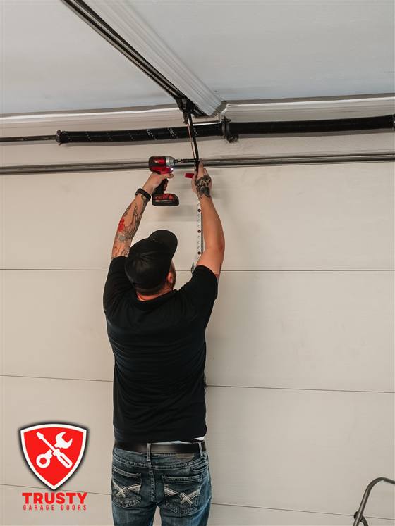 Technician installing a garage door opener bracket in Dallas, TX