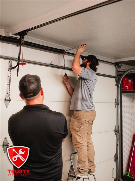 Technician installing a new garage door torsion spring in Plano, TX