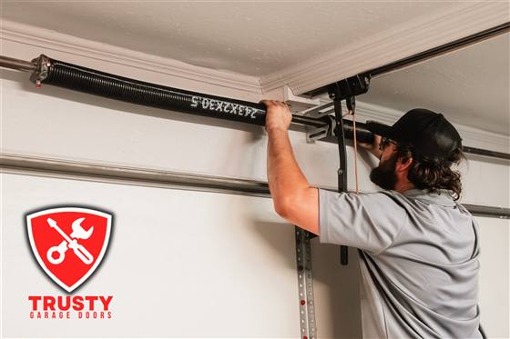 Technician replacing a garage door torsion spring in Dallas, TX